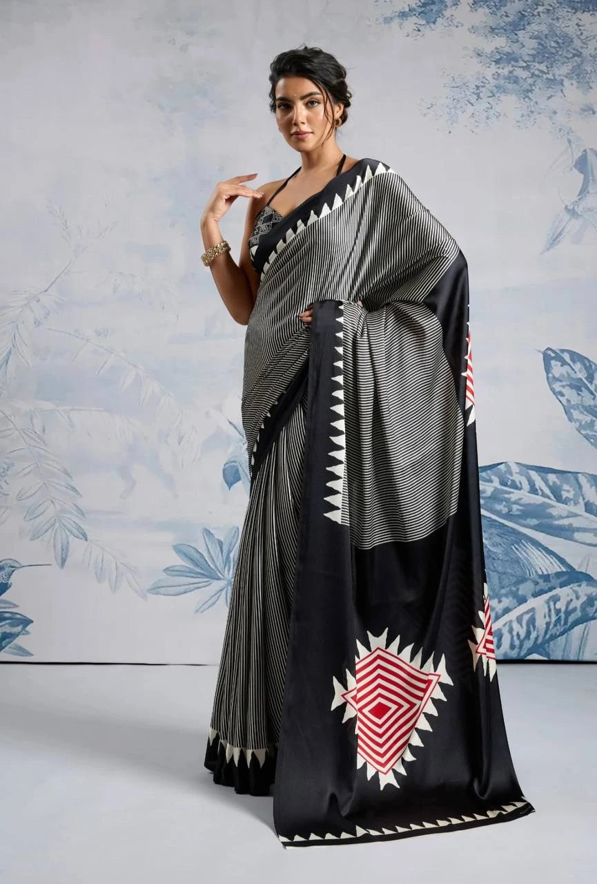 Woman wearing a black and gray saree with a geometric pattern against a light blue floral background